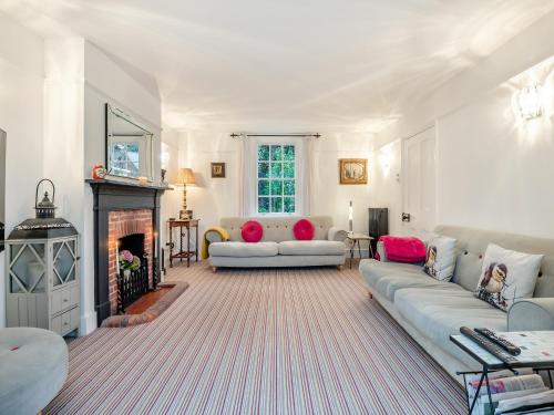 a living room with two couches and a fireplace at Victoria Cottage in Christchurch