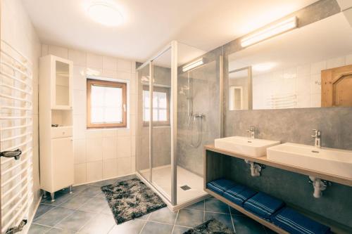 een badkamer met 2 wastafels en een douche bij Hirzbachgut in Fusch an der Glocknerstraße