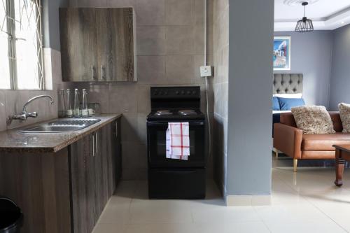 a kitchen with a stove and a sink and a couch at 235 LODGE in Durban