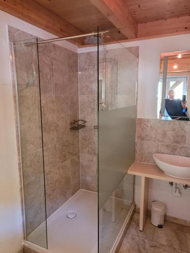 łazienka z przeszkloną kabiną prysznicową i umywalką w obiekcie Apartment Katalin w mieście Murau