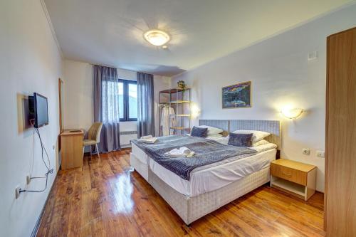 a bedroom with a bed and a television in it at Complex Silver Hills in Smolyan