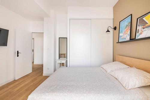 - une chambre avec des murs blancs et un grand lit dans l'établissement les LOFTS de SAINT CLAIR Un balcon à TOULON CENTRE VILLE, marché provençal, 4CH avec bureau et connexions WIFI haut débit, CLIM, 5 smart TV, 2 salles d'eau, 2WC, 8 PAX max, tout à pied, à Toulon
