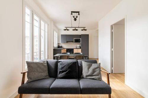 uma sala de estar com um sofá e uma cozinha em les LOFTS de Saint Clair Un balcon à Toulon LOFT 4CH CLIM 8 PAX MAX em Toulon