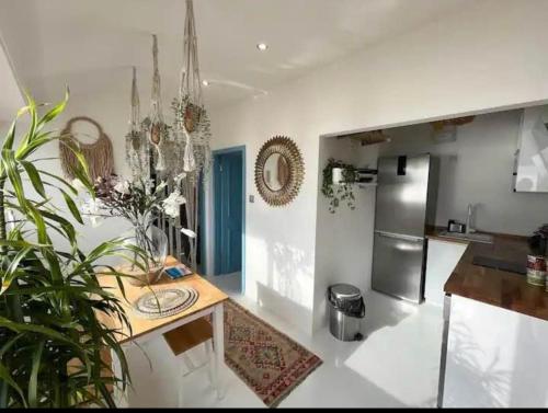 cocina con mesa y nevera de acero inoxidable en Beach Front Apartment en Gibraltar