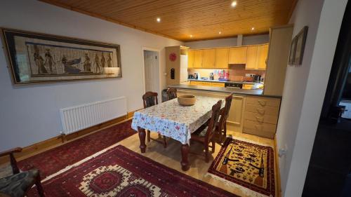 a kitchen with a table with chairs and a kitchen at Cosy home in a beautiful valley in Tipperary