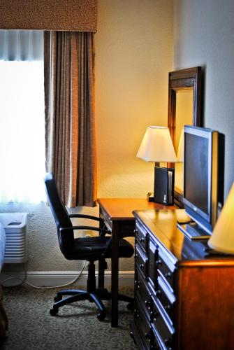 a hotel room with a desk with a chair and a television at Amelia Hotel at the Beach in Fernandina Beach