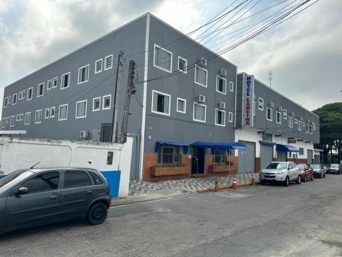 un edificio gris con autos estacionados frente a él en HOTEL LAREIRA, en São José dos Campos