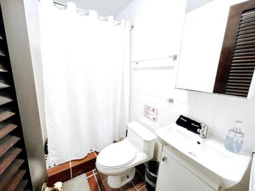 a bathroom with a white toilet and a sink at 65 Fortaleza 1 - N Colonial Apt W/ Balconies & Views in San Juan