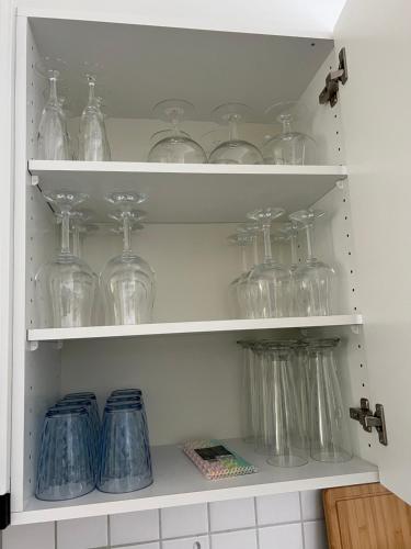 a cabinet filled with glass jars and vases at Wohnung „Perla Paradiso“ in Fluelen