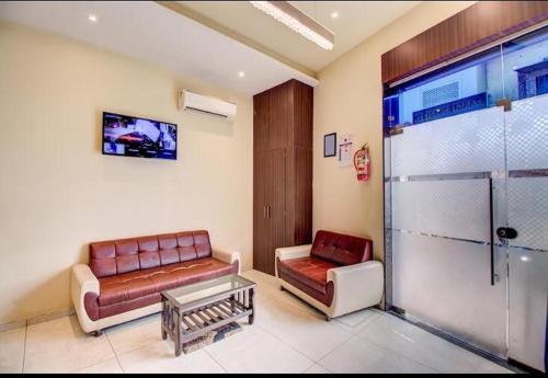 una sala de espera con dos sofás y una mesa en Hotel Emerald Near T2 International Airport Mumbai en Bombay