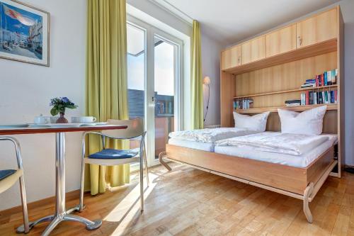 Un dormitorio con una cama y un escritorio y una ventana. en Forum Marinar, en Bansin