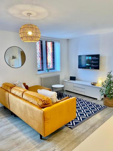 a living room with a yellow couch and a mirror at Boutique Chapel Apartment within City Walls in Chester