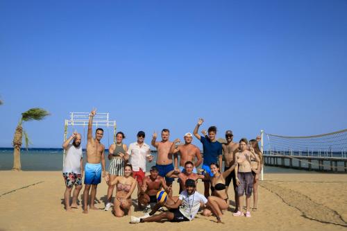 un grupo de personas posando para una foto en la playa en Amwaj Beach Club Abu Soma, en Hurghada