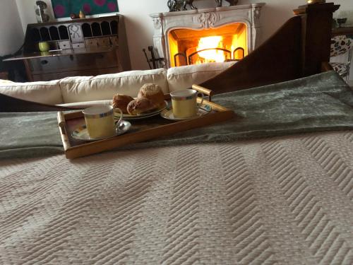 a tray with two cups and muffins on a bed at B&B Villa la Canonica con piscina a Padernello in Farfengo