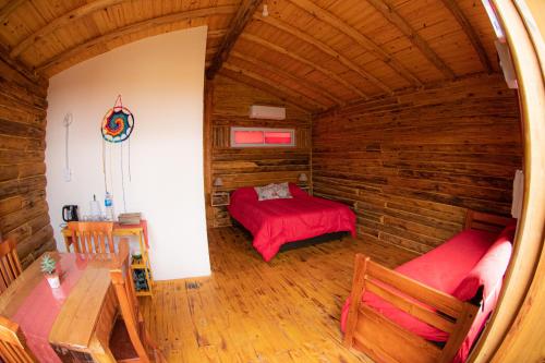 Habitación con cama en una cabaña de madera en Complejo majua en Cosquín