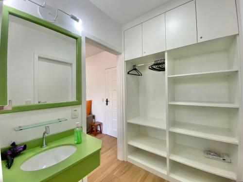 La salle de bains est pourvue d'un lavabo et d'un miroir. dans l'établissement FLAT COM VARANDA E SERVIÇOS NO RIVIERA GREEN, à Bertioga