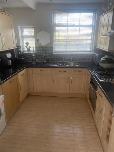 a kitchen with wooden cabinets and black counter tops at Leamington Loft in Leamington Spa