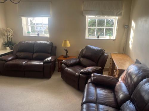 a living room with two leather chairs and a table at Leamington Loft in Leamington Spa