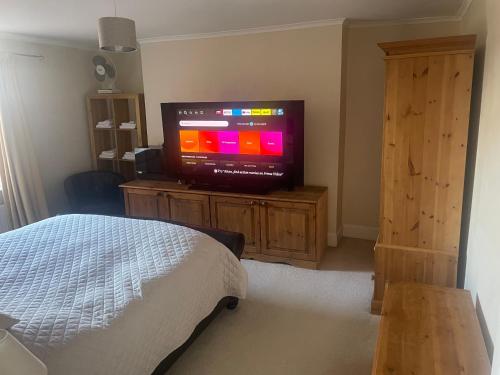 a bedroom with a tv on a wooden dresser at Leamington Loft in Leamington Spa