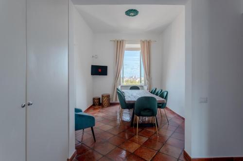 a dining room with a table and chairs and a window at The Attico: best view of Rome in Rome