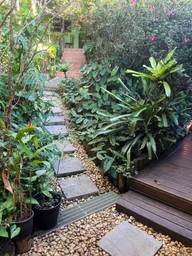 a garden with rocks and plants and a wooden walkway at Pousada Albatroz in Abraão