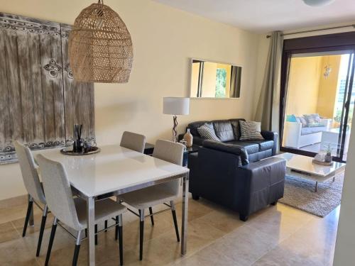 uma sala de estar com uma mesa e um sofá em Apartment Duquesa Village em Manilva