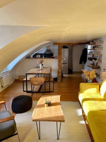 un salon avec un canapé jaune et des tables dans l'établissement Magnifique appartement Paris 10ème, à Paris