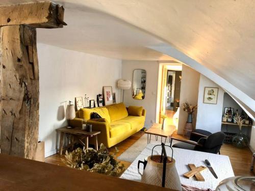 un salon avec un canapé jaune et une table dans l'établissement Magnifique appartement Paris 10ème, à Paris