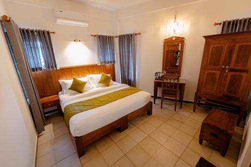 ein Schlafzimmer mit einem großen Bett in einem Zimmer in der Unterkunft SeaCoast Inn FortKochi in Fort Kochi