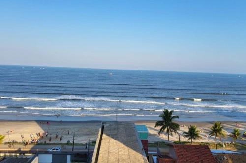 a view of a beach with palm trees and the ocean at Apto. a 40m da praia - Itanhaém. in Itanhaém