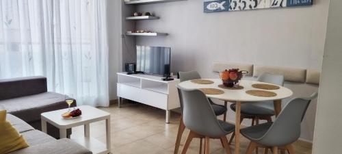 sala de estar con mesa blanca y sillas en La Pausa, en Gandía