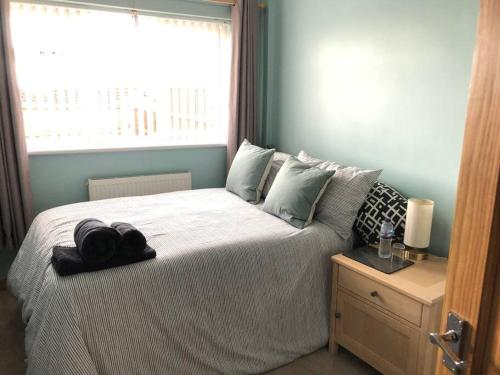 een slaapkamer met een groot bed en een raam bij 2 Bedroom entire Bungalow with off road parking in the heart of Stoke in Stoke on Trent