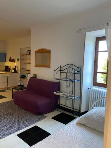un salon avec un canapé violet et une chambre dans l'établissement Lou-Pelou, à Gravières