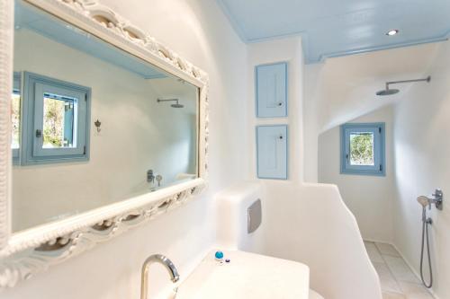 a bathroom with a large mirror and a sink at Azure Villa Paros in Drios