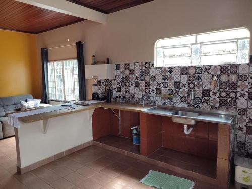 uma cozinha com um balcão e um lavatório em Casa LB com estacionamento privado em Boa Vista