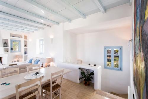 a white living room with a white table and chairs at Azure Villa Paros in Drios