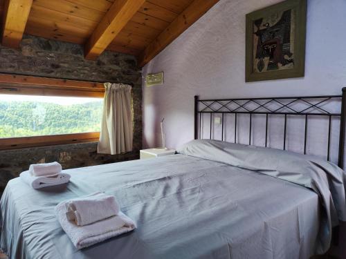 um quarto com uma cama com duas toalhas em La Cabanya de Can Menut em Molló