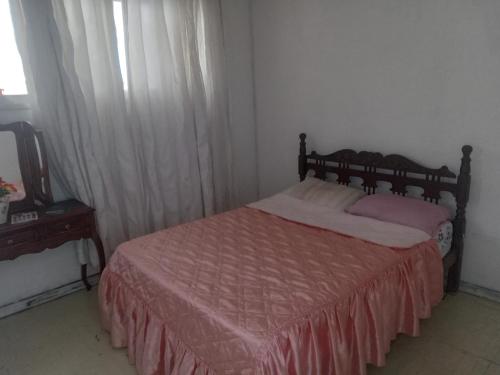 Schlafzimmer mit einem Bett mit einer roten Tagesdecke in der Unterkunft Hostel Leonardo in Vitória