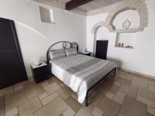 a bedroom with a bed in a white room at Trullo Civico 25, Cummersa Civico 23 in Alberobello