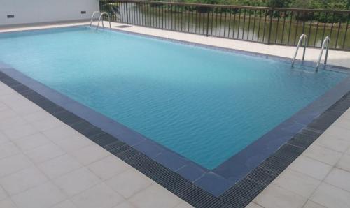una piscina de agua azul en un edificio en Diyawanna Leisure en Rajagiriya