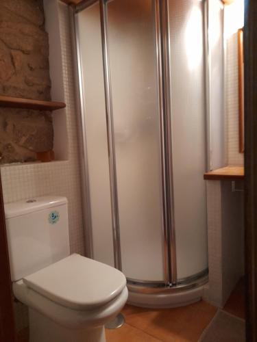 La salle de bains est pourvue d'une douche et de toilettes blanches. dans l'établissement A Casa da Gombra, à Villanueva de Arosa