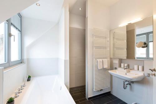 La salle de bains est pourvue d'un lavabo et d'un miroir. dans l'établissement Ostsee - Reetdachhaus Nr 43 "Ostseestern" im Strand Resort, à Heiligenhafen