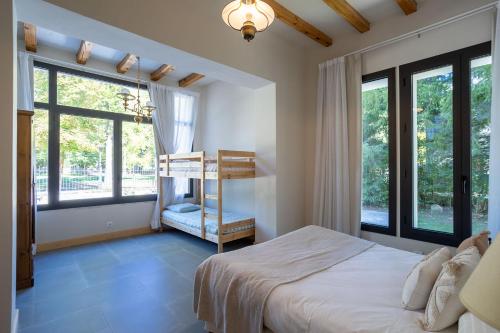 a bedroom with a bed and large windows at Casa Maristany in Camprodon