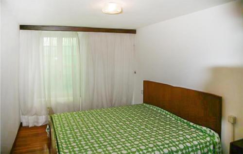 una camera da letto con un letto con un piumone verde e una finestra di Baidoni Secondo Piano a Ponte Caffaro