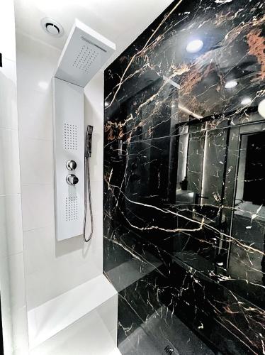 a bathroom with a black marble wall at Suite in the City avec JACUZZI PRIVATIF - Hyper Centre in Montpellier