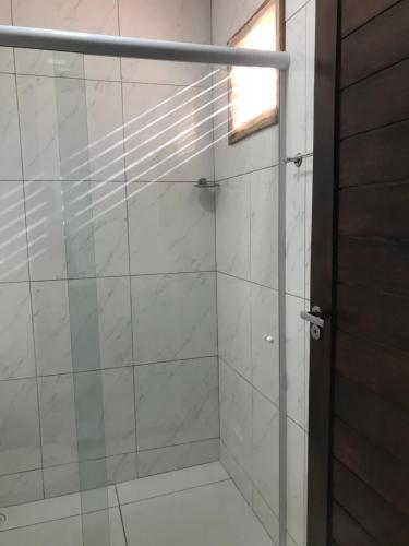 a shower with a glass door and a window at Casa Blanca in Galinhos