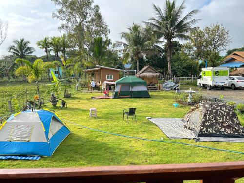 um grupo de tendas num campo com árvores em PJ Kingdom Camps 