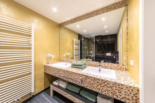 a bathroom with two sinks and a large mirror at PMC Business Apartments in Rüsselsheim