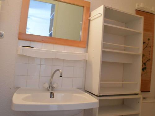 a bathroom with a sink and a mirror and shelves at Maison Fleury-Saint-Pierre-la-Mer, 3 pièces, 6 personnes - FR-1-229D-227 in Saint Pierre La Mer