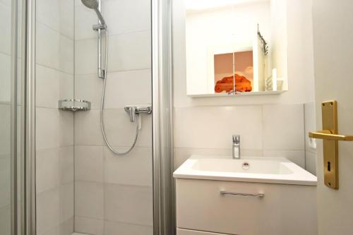 ein Bad mit einem Waschbecken und einer Dusche in der Unterkunft Appartment Mocker in Hörnum